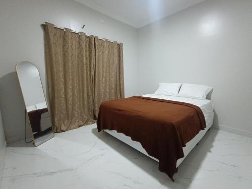 a small bedroom with a bed and a window at Xodó de Casa, Paracuru in Paracuru
