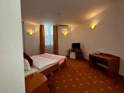 a hotel room with a bed and a desk at Hotel Atlantis in Tulcea