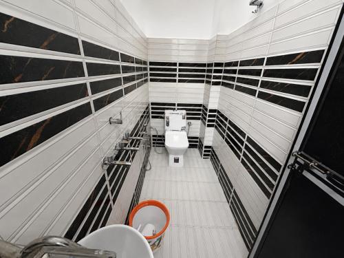 a bathroom with a toilet and black and white stripes at Hotel Vishnu Priya Ayodhya in Ayodhya