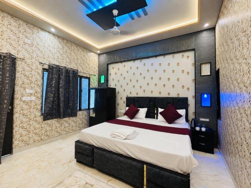 a bedroom with a large bed with red pillows at Hotel Vishnu Priya Ayodhya in Ayodhya