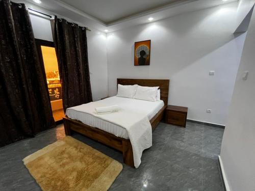 a bedroom with a bed and a large window at Sall Africa Tourisme in Mbour