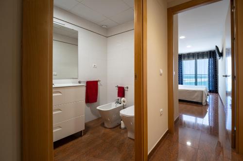 a bathroom with a sink and a toilet and a bed at ANCLA spaces EGVT-436-CS in Vinarós