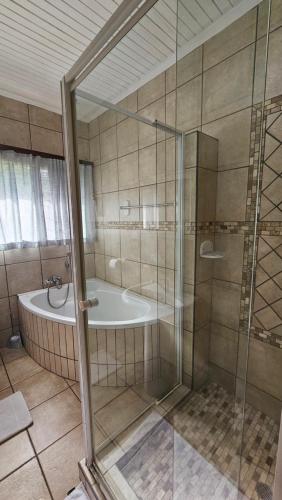 a bathroom with a shower and a tub and a sink at Fisherman's 6-Bedroom Family Home in St Lucia