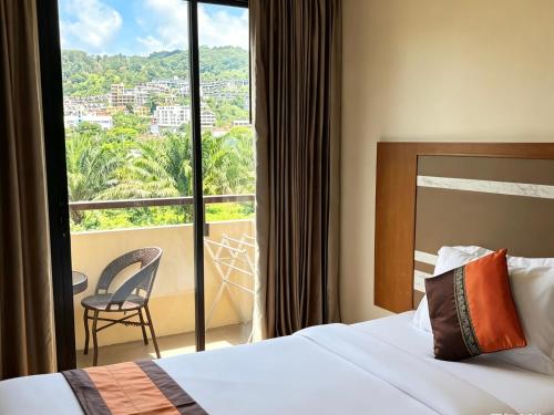 a hotel room with a bed and a large window at patong v hotel in Patong Beach
