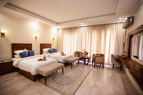 a hotel room with two beds and a television at Alhamra Hotel in Mardan
