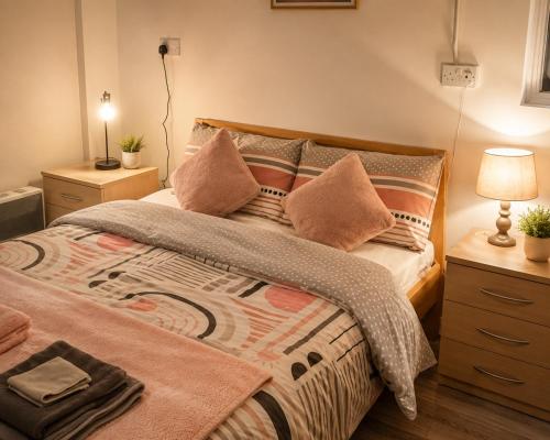 a bedroom with a bed with a blanket and pillows at Farm Lodge in Monaghan