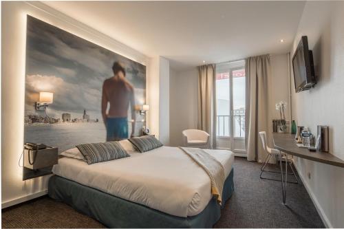 a hotel room with a bed and a painting of a man at Best Western ARThotel in Le Havre