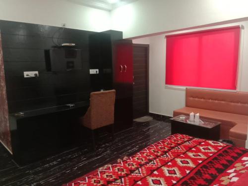 a bedroom with a red window and a bed and a tub at hotel shivay in Basti