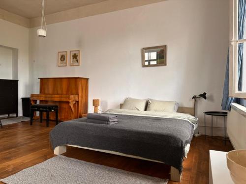 a bedroom with a large bed and a piano at Room 0 in The White House Residence in Kuldīga