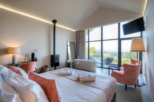 a hotel room with a large bed and a tub at Casa Valxisto in Penafiel