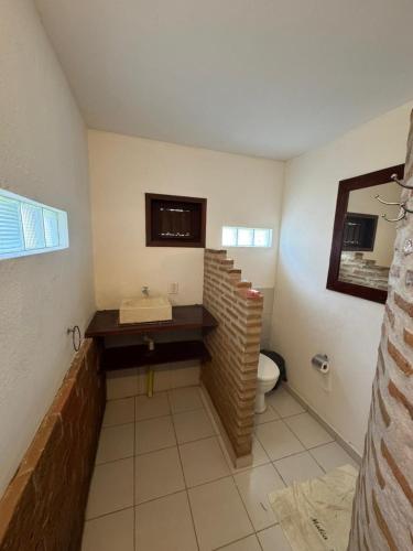 a bathroom with a brick sink and a toilet at Pousada Maraí in Amontada
