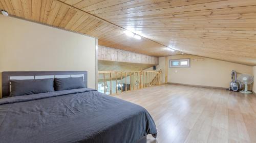 a bedroom with a bed and a wooden ceiling at Suncheonman Muhan Dojan Pension in Suncheon
