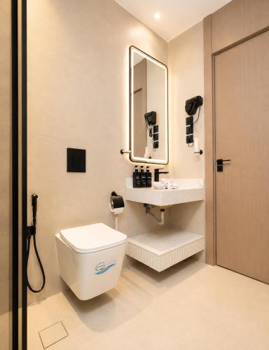 a bathroom with a toilet and a sink and a mirror at السميح للشقق الذاتيه ALsUMAIH HOTELAPARTMENTS in Riyadh