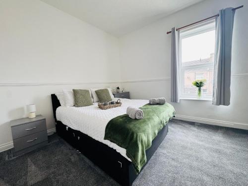 a white bedroom with a large bed and a window at Bolton Terrace - 2 Bedrooms - Sleeps 4 in Workington
