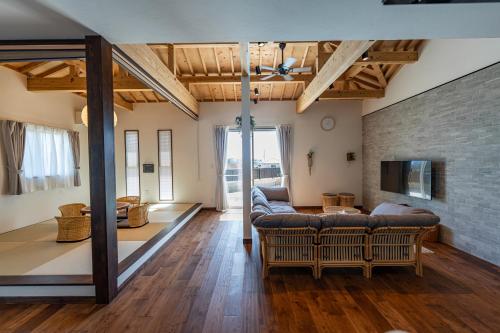 a living room with couches and a brick wall at Villa Arco Miyakojima in Miyako-jima
