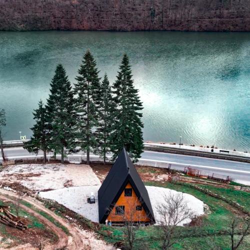 a small house in front of a body of water at Ovcharka House in Međuvršje