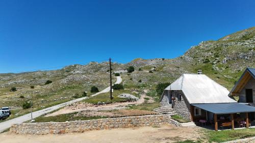 a small building in front of a mountain at Miris Katuna - Sinjajevina in Šavnik