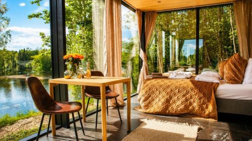 a room with a bed and a table and chairs at WonderInn Riverside in Årnes