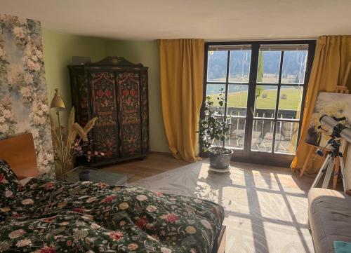 a living room with a couch and a large window at Villa overlooking Lake Thiersee in Vorderthiersee