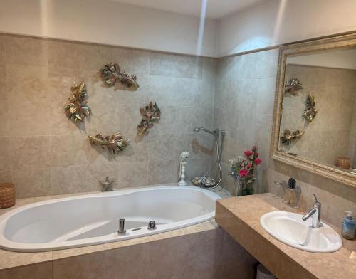 a bathroom with a tub and a sink and a mirror at Villa overlooking Lake Thiersee in Vorderthiersee