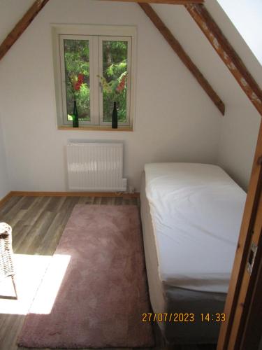 a bedroom with a bed and a window at Mysig huset in Strömsnäsbruk