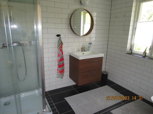 a bathroom with a sink and a shower and a mirror at Mysig huset in Strömsnäsbruk