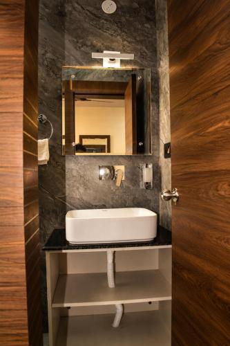 a bathroom with a sink and a mirror at DEO SIGNATURE SUITE Hotel in Rānchī