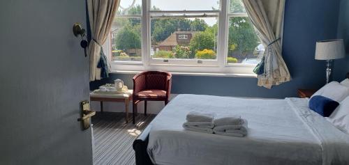 a bedroom with a bed with towels on it at Seabrook House Hotel in Hythe