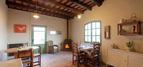 comedor con mesas y sillas y chimenea en Masia CasaJoana Rural, en Rellinars