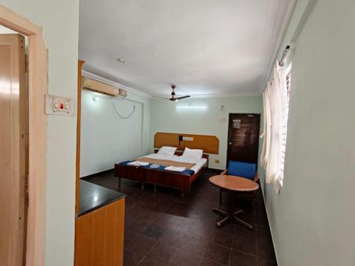 a bedroom with a bed and a table in a room at Balaji inn in Anantapur