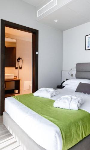ein Schlafzimmer mit zwei weißen Betten mit grünen Laken in der Unterkunft LaLuna - Ruhe & Behaglichkeit am Stadtrand von Köln - in Lohmar