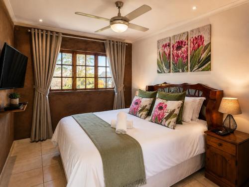 a bedroom with a bed and a ceiling fan at Linglela Lodge in Estcourt