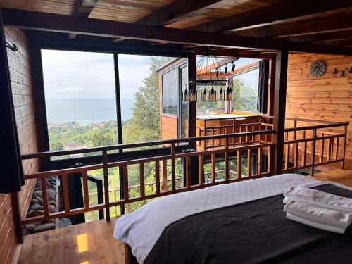 a bedroom with a large window in a log cabin at Novella Bungalov in Işıklı