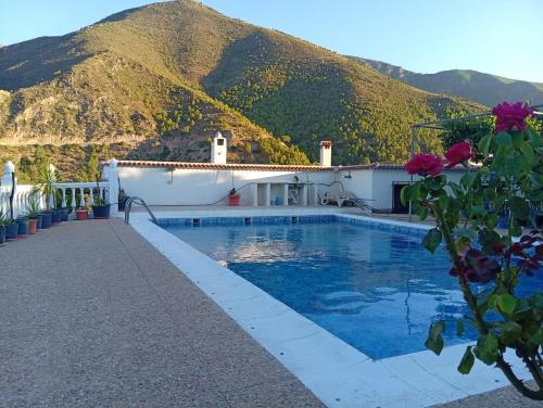 a swimming pool with a mountain in the background at Casa Aguas Claras in Órgiva