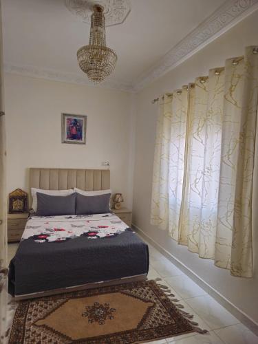 a bedroom with a bed and a window with curtains at Marrakech héberg in Marrakesh