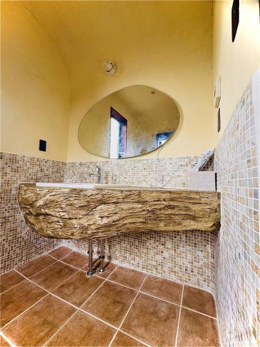 a bathroom with a large wooden counter with a mirror at WAAP Hotel in Ishigaki Island