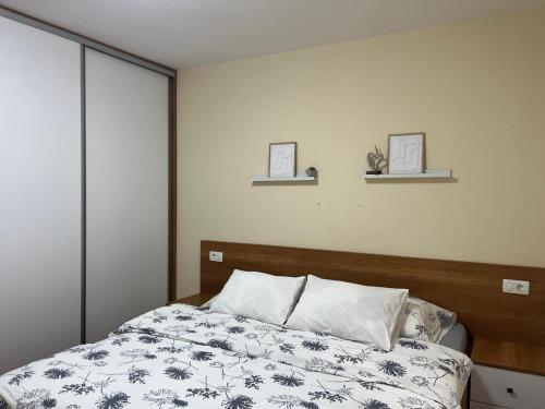 a bedroom with a bed and two shelves on the wall at Luxury Apartment Lara Mostar in Mostar