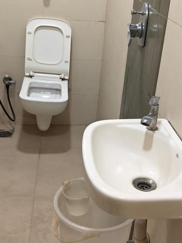 a bathroom with a sink and a toilet at Hotel Sai Praatham in Shirdi