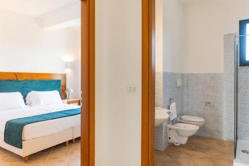 ein Schlafzimmer mit Bett und ein Badezimmer mit Toilette in der Unterkunft Baglio Basile - CDSHotels in Petrosino