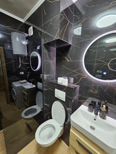 a bathroom with a toilet and a sink and a mirror at Luxury Apartment Lara Mostar in Mostar