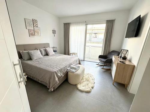 a bedroom with a bed and a television and a chair at Casa sissy in Chioggia