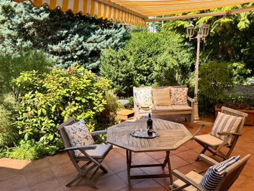 eine Terrasse mit Tisch, Stühlen und einer Bank in der Unterkunft Inge's Arthouse & Gardenlounge, bei Frankfurt in Eschborn
