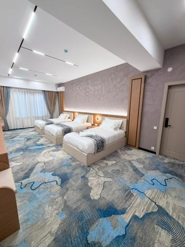 a hotel room with two beds and a carpet with a map at Keruen in Almaty