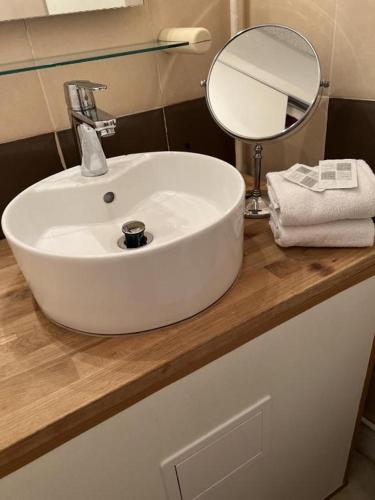 a white sink on a counter with a mirror at Hôtel Abalone - Centre Gare in Nîmes