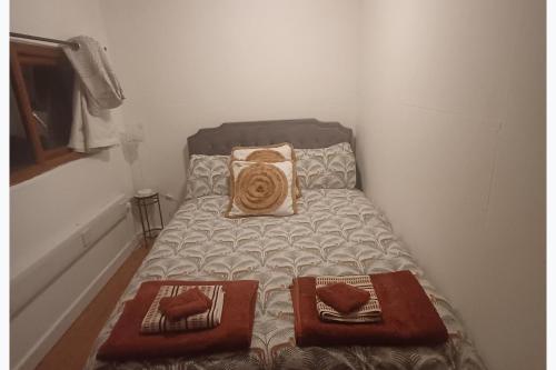 a small bed with two pillows on it in a room at Inviting 1-Bed Cottage in Pontypridd in Pontypridd