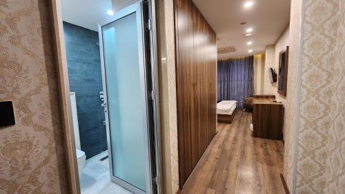 a hallway with a glass door leading to a bathroom at Al Baron Hotel - فندق البارون in Al Mawşil