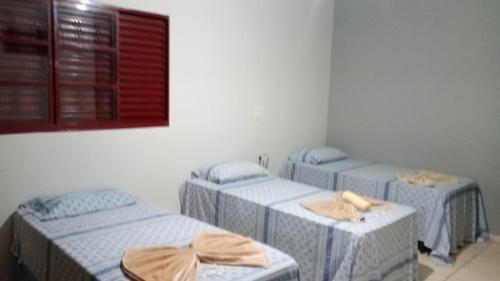 a group of four beds in a room at Primeiro Hotel in Ilha Solteira