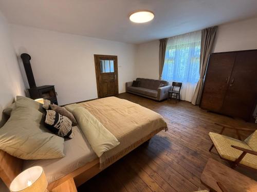 a bedroom with a bed and a couch in it at Dvor u Hrivka in Heľpa