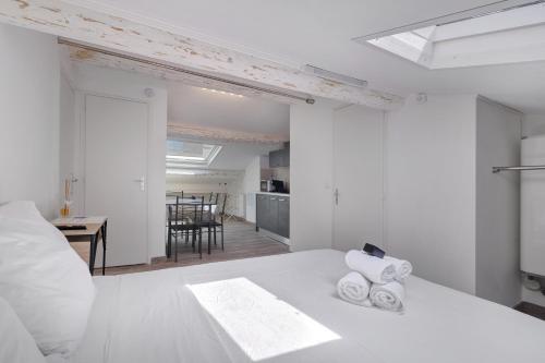 a white bedroom with a bed with towels on it at Studio Centre Cannes, Rue d’Antibes in Cannes
