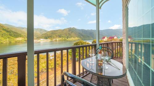 a table on a balcony with a view of a river at Gapyeong Elin Pension in Gapyeong